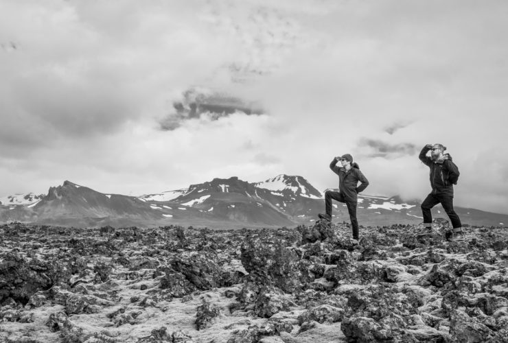 Two men on a mountain looking out over the land