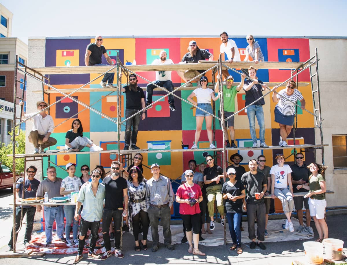 John Wayne Hill with Ancestry Design Team in front of mural they are painting in Provo, Utah